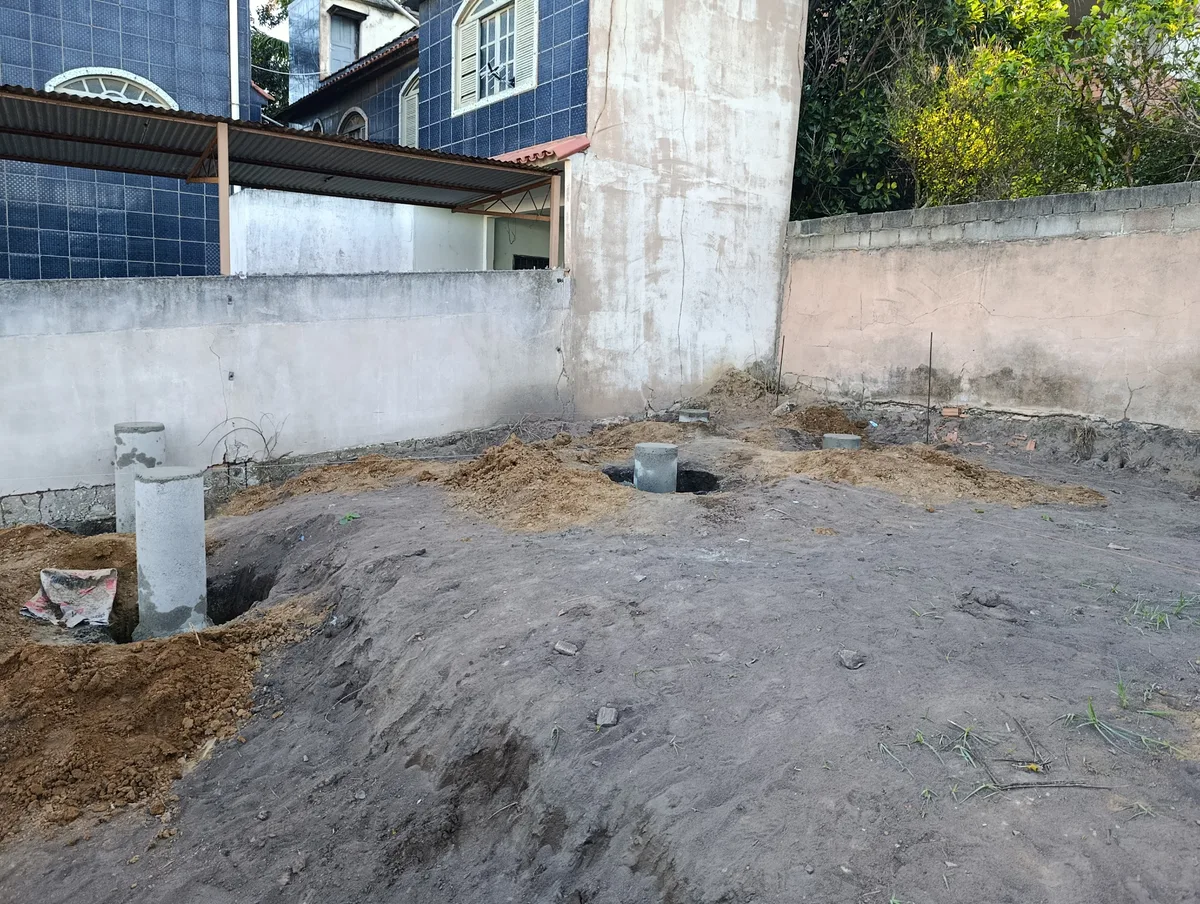 Canteiro de obra com conjunto de pilares em manilhas nivelados e alinhados para casa container